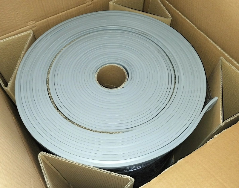 A CNC machine precisely cutting a roll of vinyl material for custom curtain sizes.